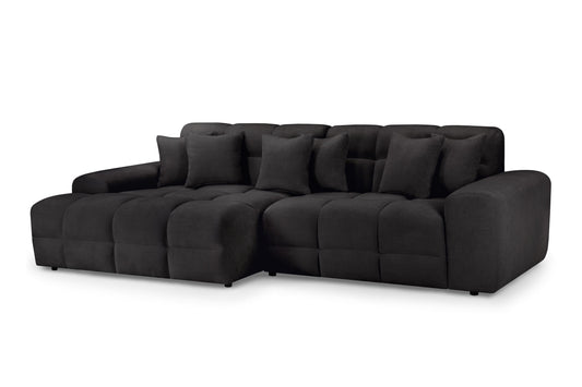 Large dark gray corner sofa with cushioned seats, broad arms, and loose back pillows