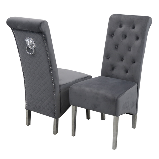 Pair of dark grey velvet dining chairs with tufted backs, quilted sides and lion-head ring pulls