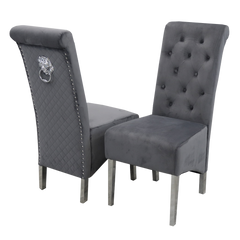 Pair of dark grey velvet dining chairs with tufted backs, quilted sides and lion-head ring pulls