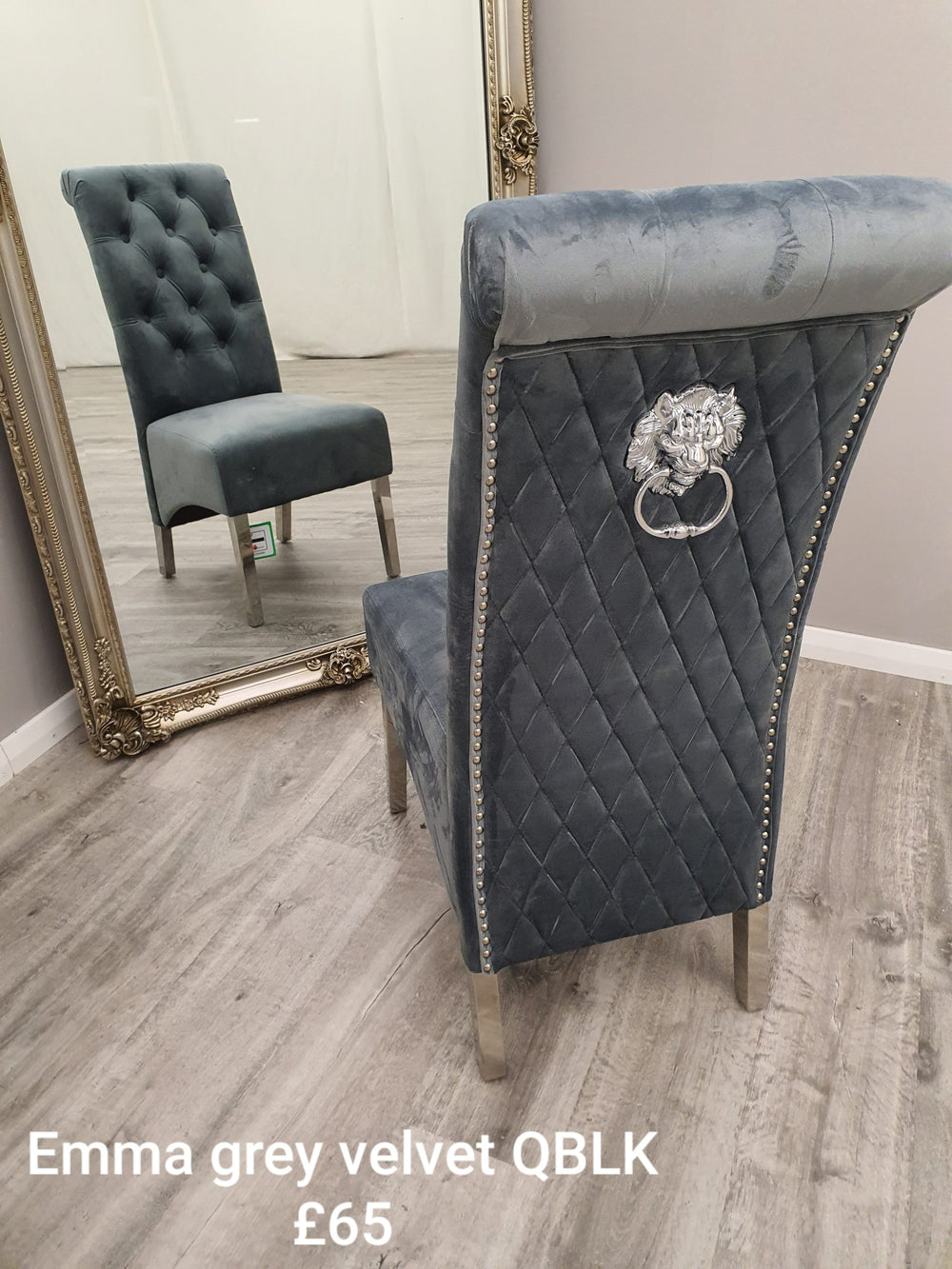 Grey velvet dining chair showing its quilted back, nailhead trim and lion-head ring pull