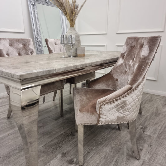 Beige velvet dining chair with button-tufted back, quilted sides and chrome legs, shown beside a table