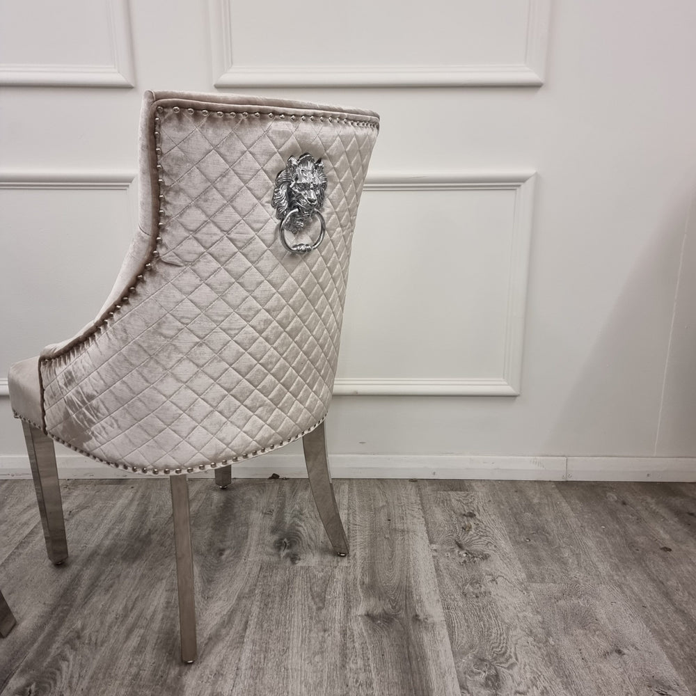 Dining chair back with quilted beige velvet, chrome lion-head accent and metal legs