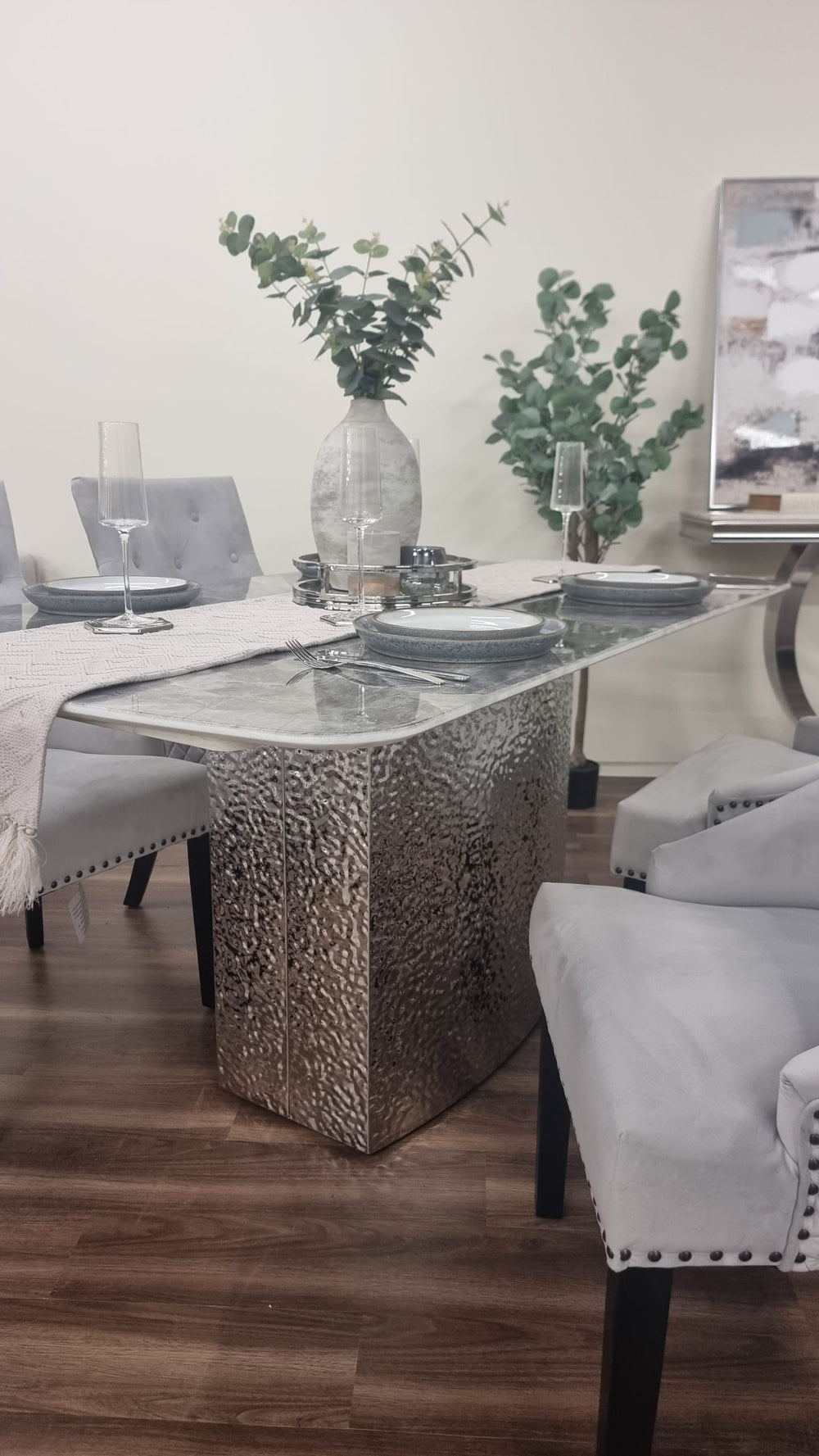 Louis Chrome dining table with a gray veined top and textured pedestal base