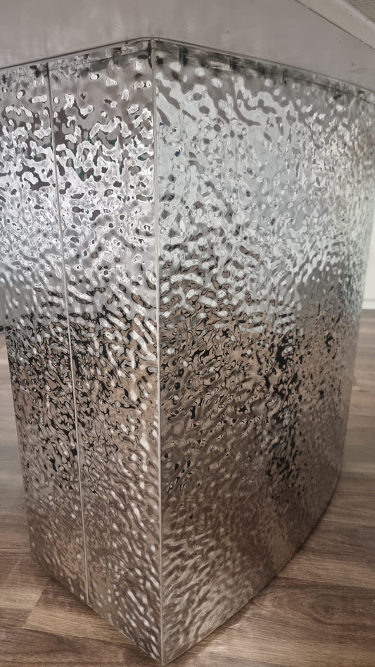 Close-up of the dining table's hammered, textured pedestal base