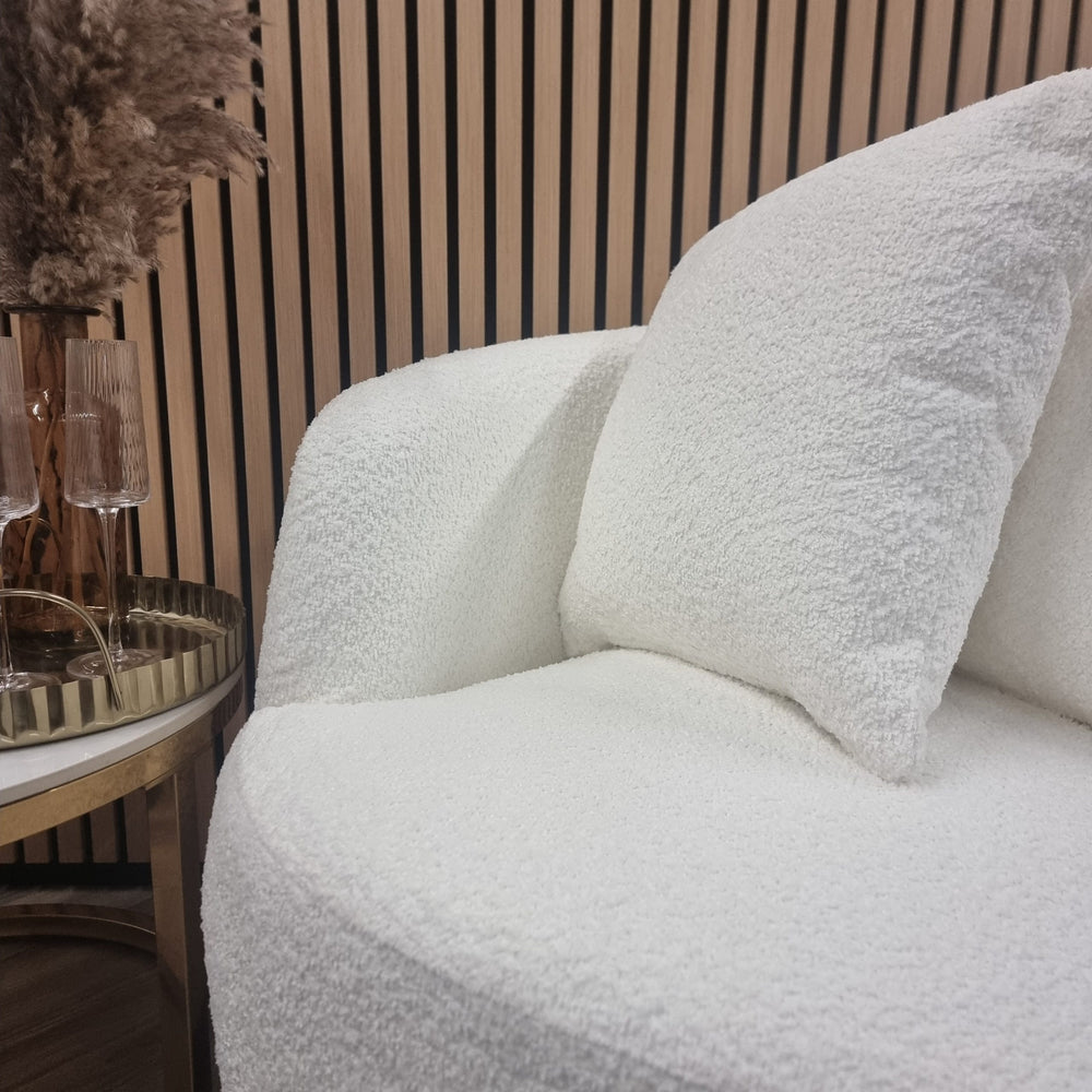Close-up of the chair's textured white teddy fabric, seat, arm, and cushion
