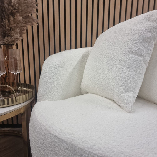 Close-up of the chair's textured white teddy fabric, seat, arm, and cushion