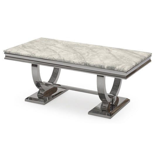 Arriana dining table with a pale veined stone top and polished metal loop legs