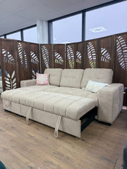 Palermo sofa bed extended, showing its beige upholstery and pull straps