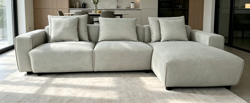 Light gray corner sofa with a right-side chaise and three loose back cushions
