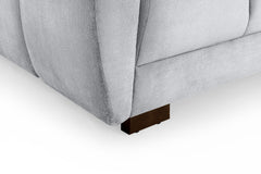 Azzuro sofa close-up showing the padded arm, upholstery seam, and dark wood foot