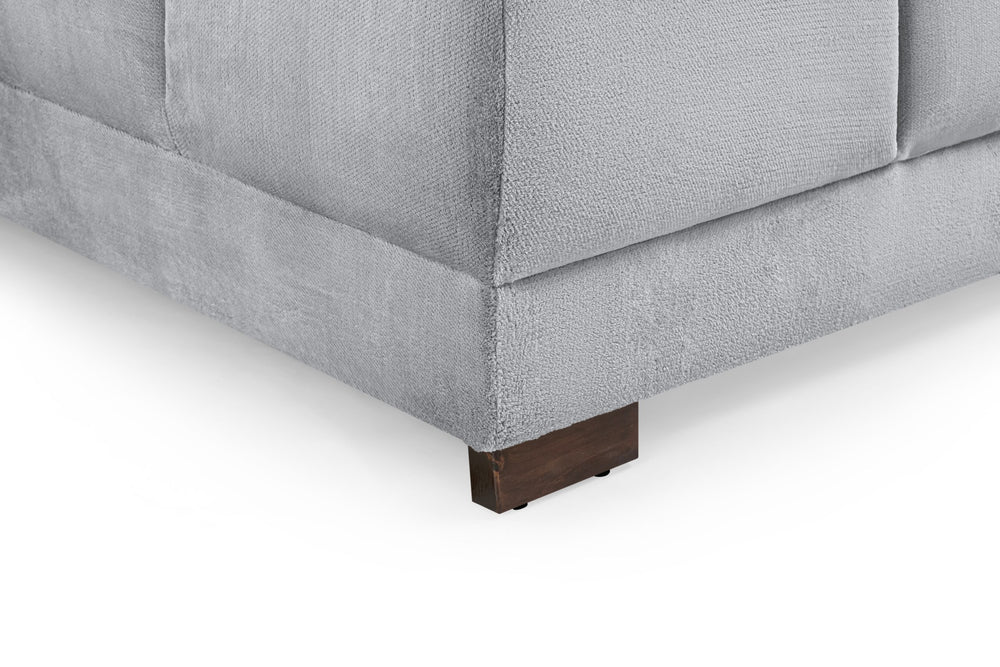 Azzuro sofa close-up showing gray upholstery seams and a dark wood foot