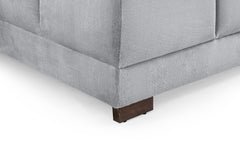 Azzuro sofa close-up showing gray upholstery seams and a dark wood foot