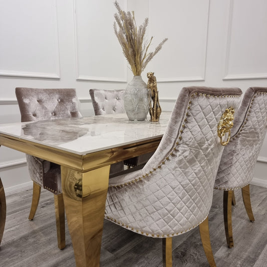 Beige velvet dining chairs with quilted backs and gold lion-head accents around a dining table