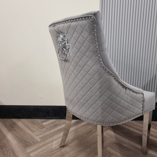 Light grey dining chair with a quilted back, nailhead trim and chrome legs