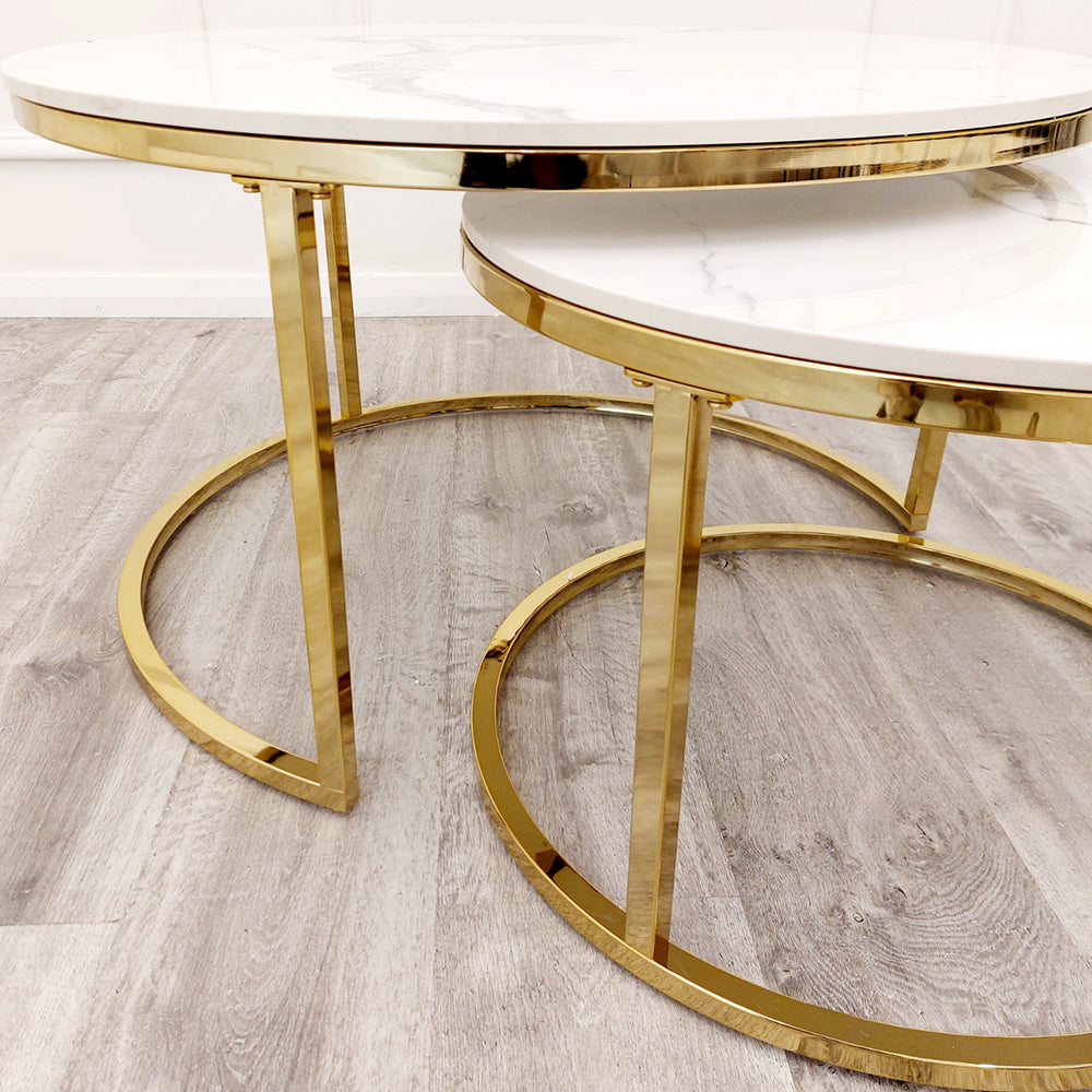Gold metal frames and circular bases of nested end tables with white stone tops