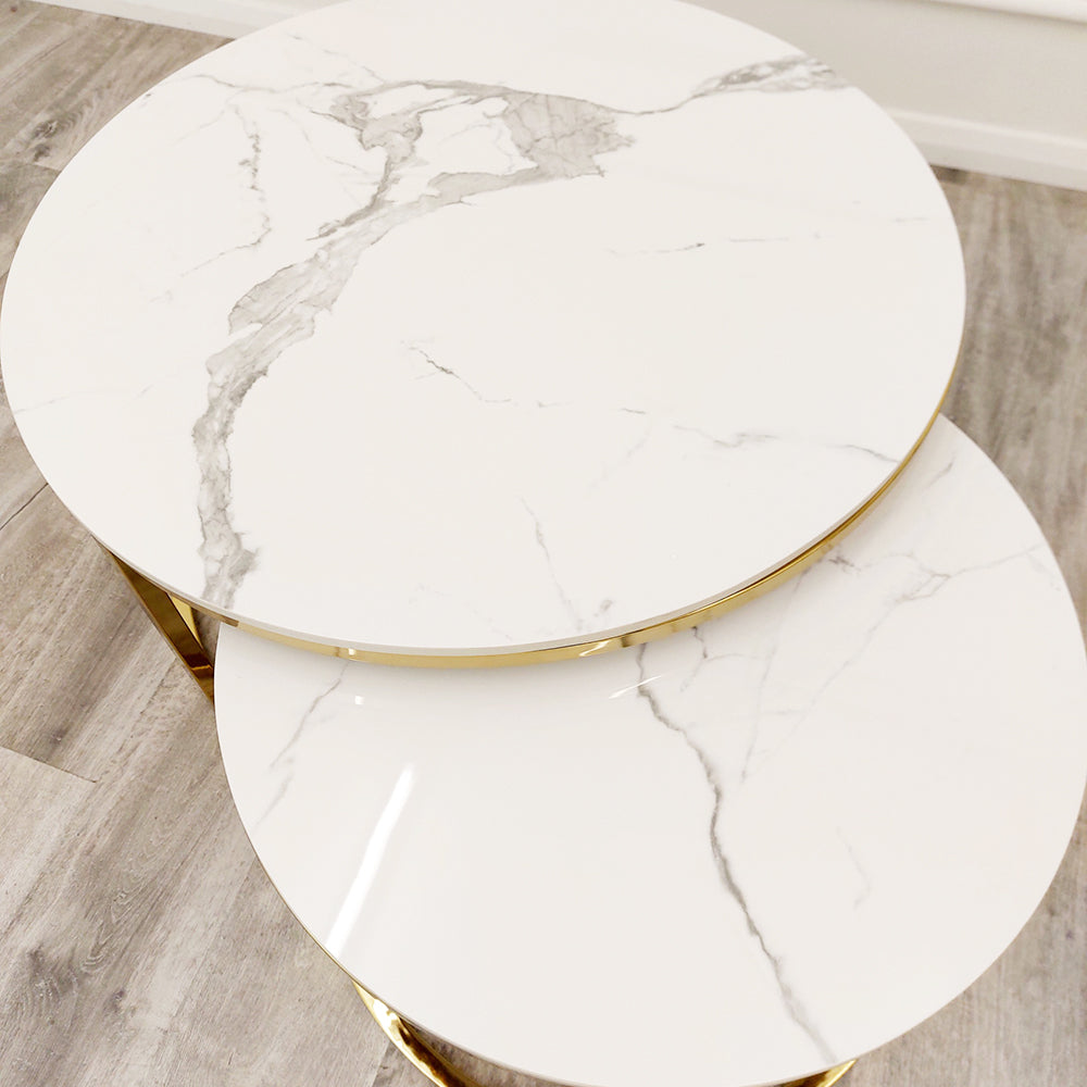 Nested end tables with round white stone tops and gray veining, viewed from above