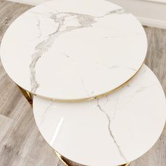 Nested end tables with round white stone tops and gray veining, viewed from above