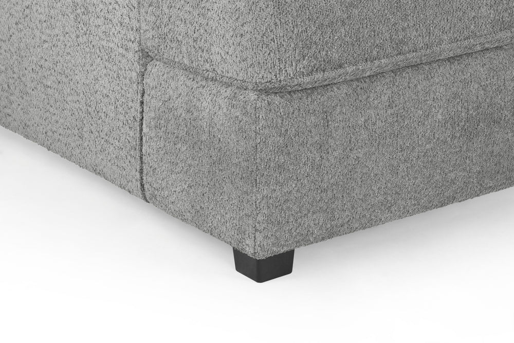Close-up of gray sofa upholstery, stitched corner, and black foot