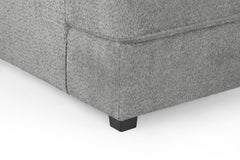 Close-up of gray sofa upholstery, stitched corner, and black foot