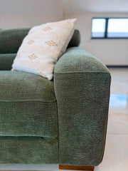 Corner sofa close-up of a broad upholstered armrest, seat cushion, and wooden foot
