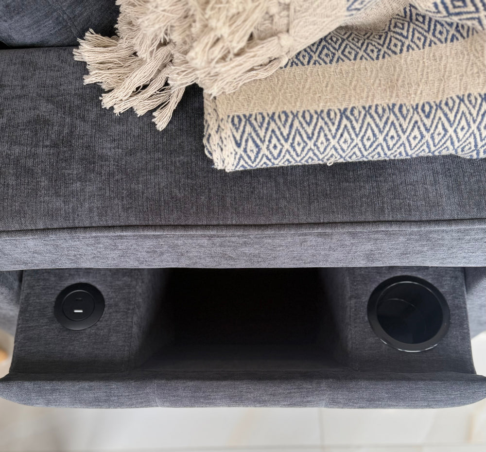 Close-up of sofa arm with two built-in cup holders and central storage compartment