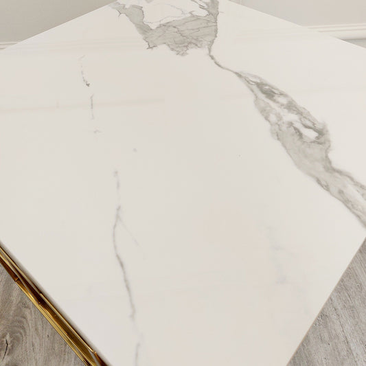Close-up of the table's white top with gray veining and gold edge