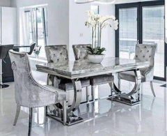 Arriana dining table with gray veined top and upholstered chairs in a dining room