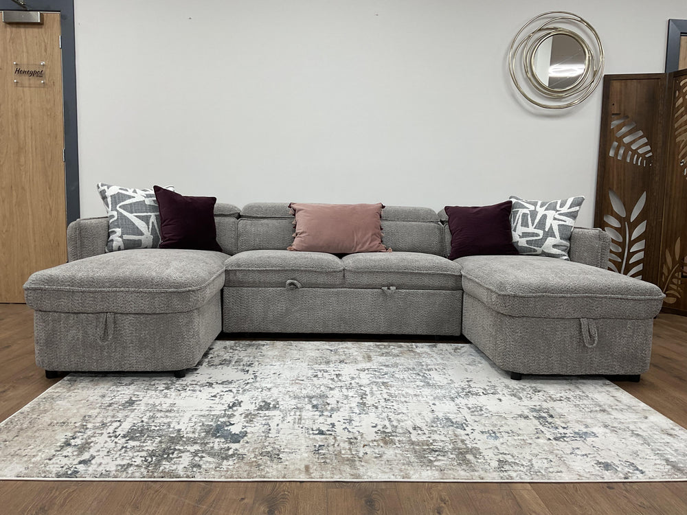 Capri U-shaped sofa bed with gray upholstery and decorative throw pillows