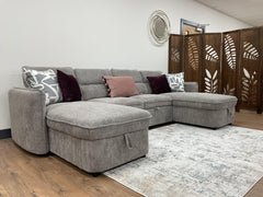Capri U-shaped sofa bed with gray textured fabric and throw pillows, angled view