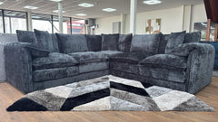 Large dark gray L-shaped corner sofa with deep seats, loose cushions, and broad arms.