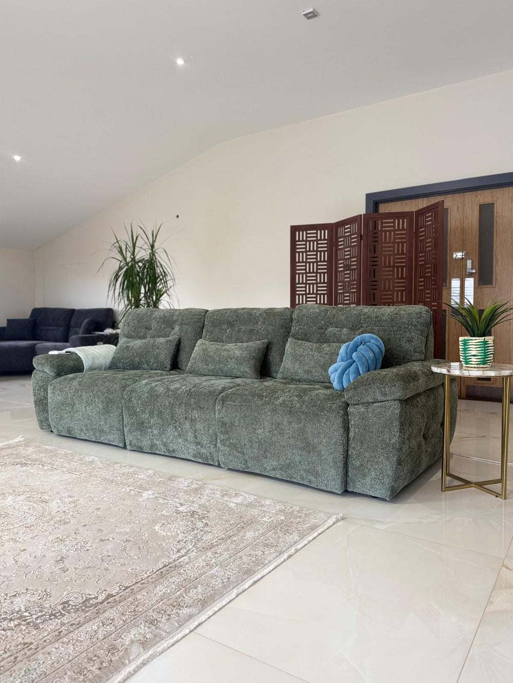 Gray-green 3-seater sofa bed with loose cushions and broad padded arms.