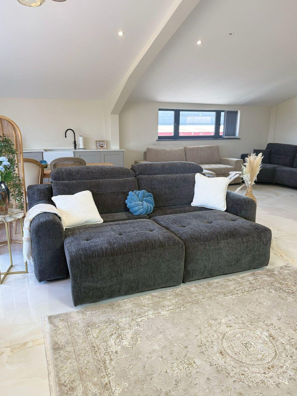 Angled view of the dark gray three-seat sofa bed with extended seat sections