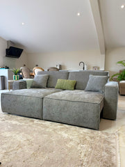 Gray three-seat sofa bed with broad seat cushions and two gray pillows