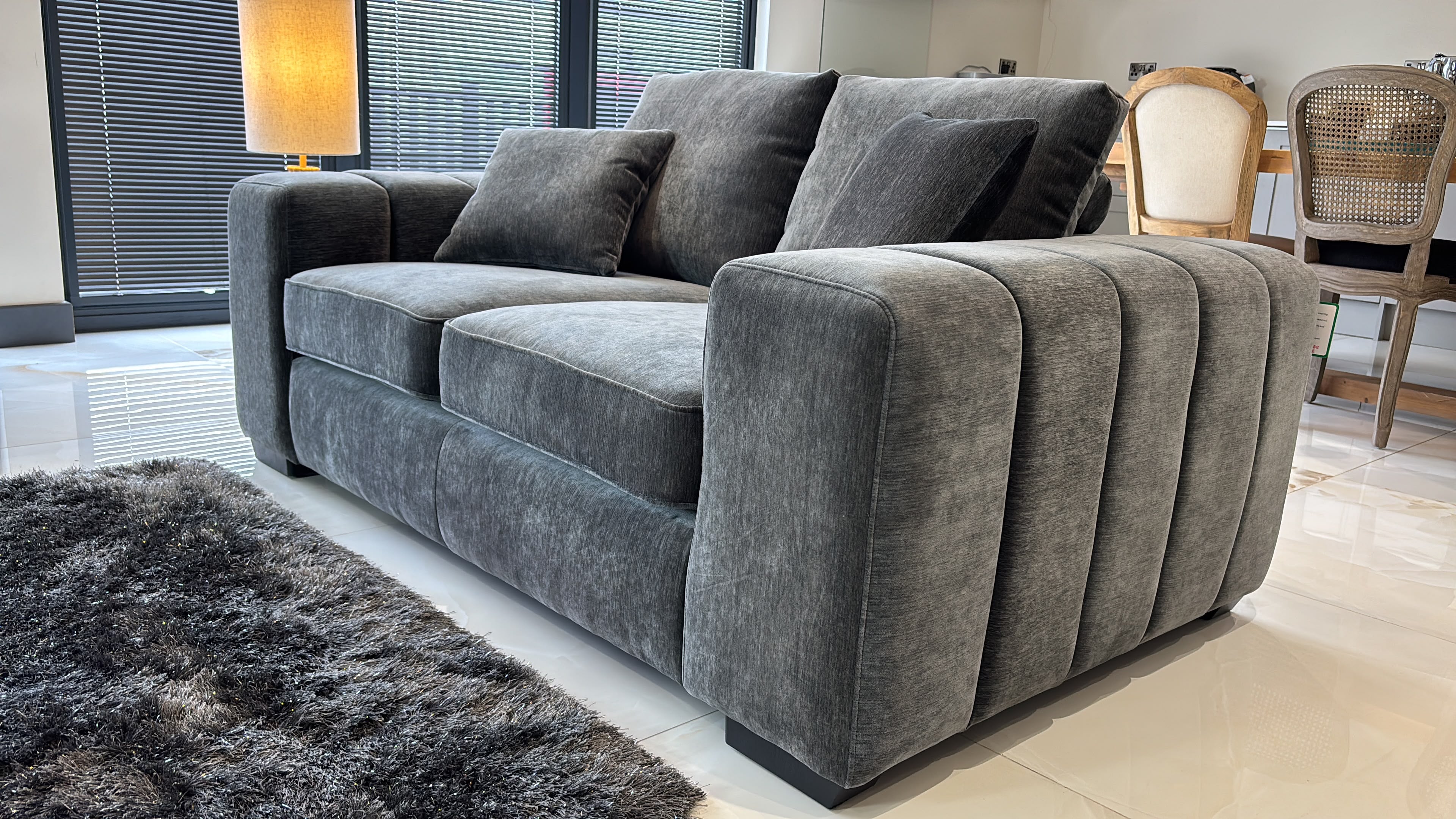 Gray two-seat sofa with plush cushions and deeply ribbed arms