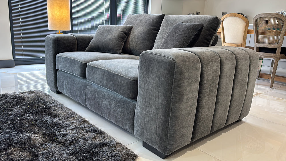 Gray two-seat sofa with plush cushions and deeply ribbed arms
