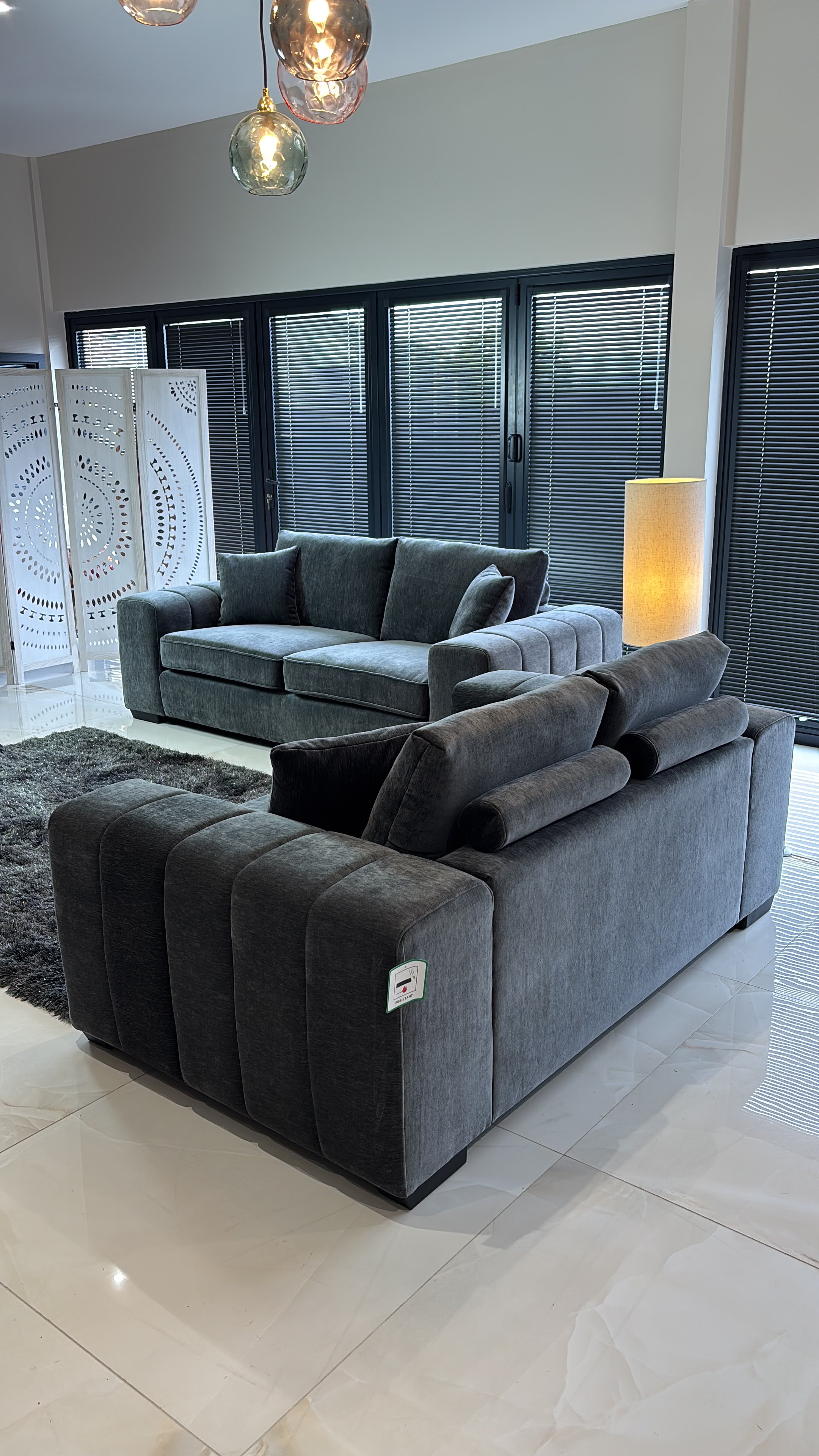 Gray sofa set viewed from behind, with ribbed arms and cushioned backs
