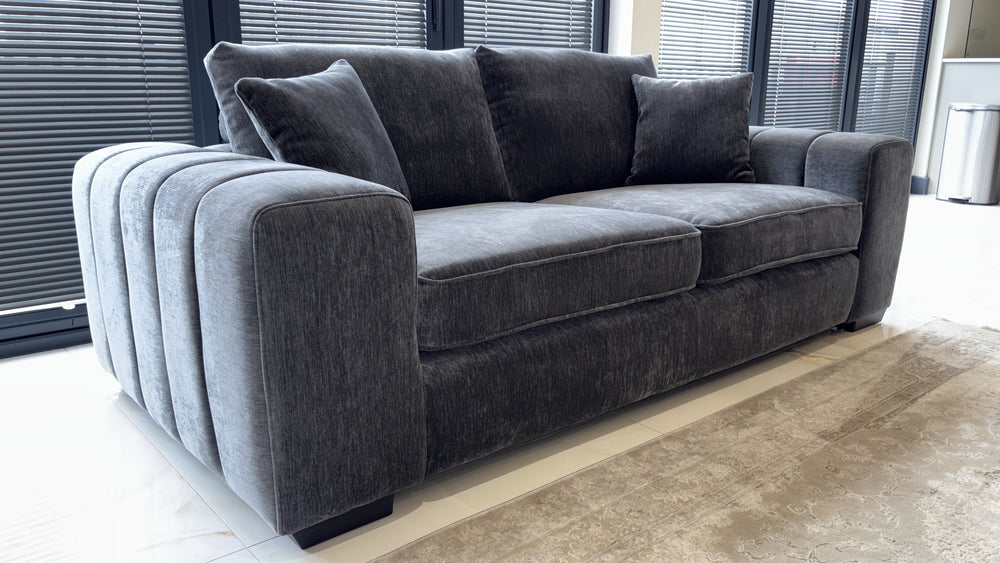 Gray three-seat sofa with plush cushions and rounded, ribbed arms
