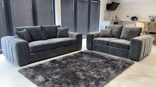 Gray sofa set with two sofas, plush cushions and rounded, ribbed arms