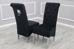 Set of two black velvet dining chairs with button-tufted backs, silver legs and decorative back rings