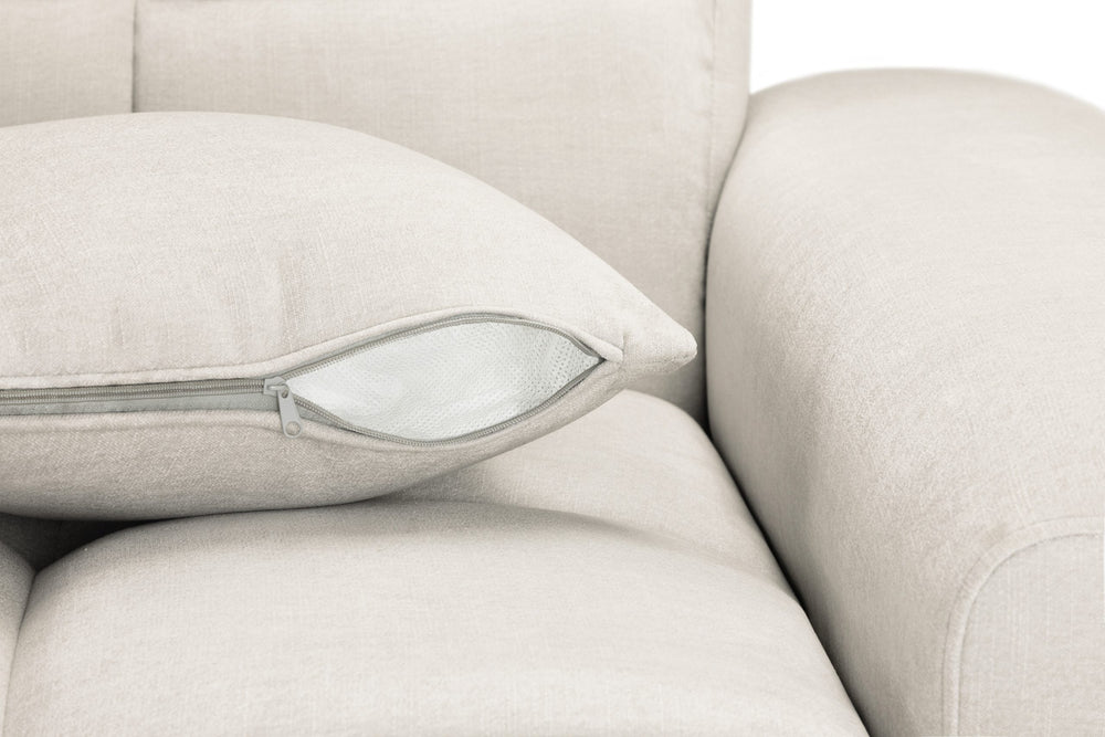 Sofa seat cushion with a zippered cover beside the upholstered arm
