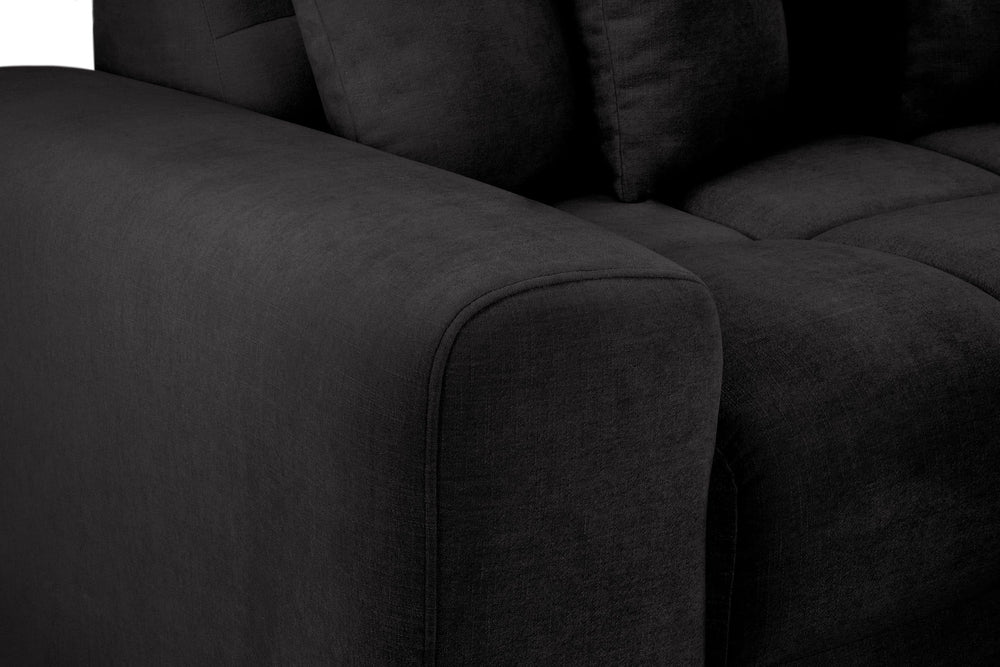 Close-up of the sofa's dark gray upholstered arm and seat cushions