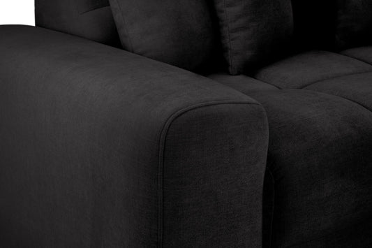 Close-up of the sofa's dark gray upholstered arm and seat cushions