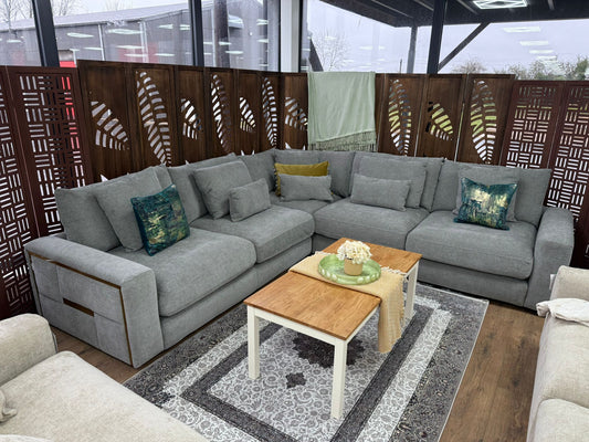 Large gray full-back corner sofa with loose cushions and wood-trimmed arms