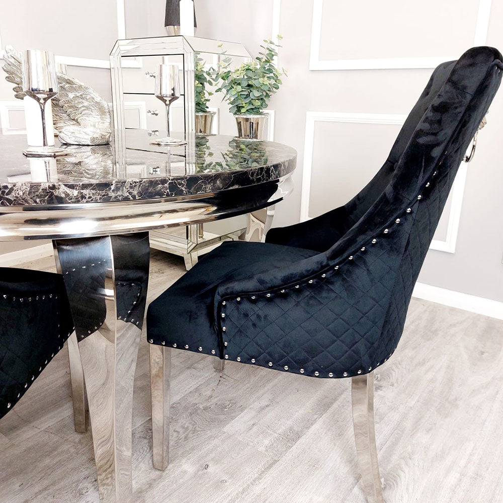 Side view of a black velvet dining chair with a quilted back, nailhead trim and chrome legs