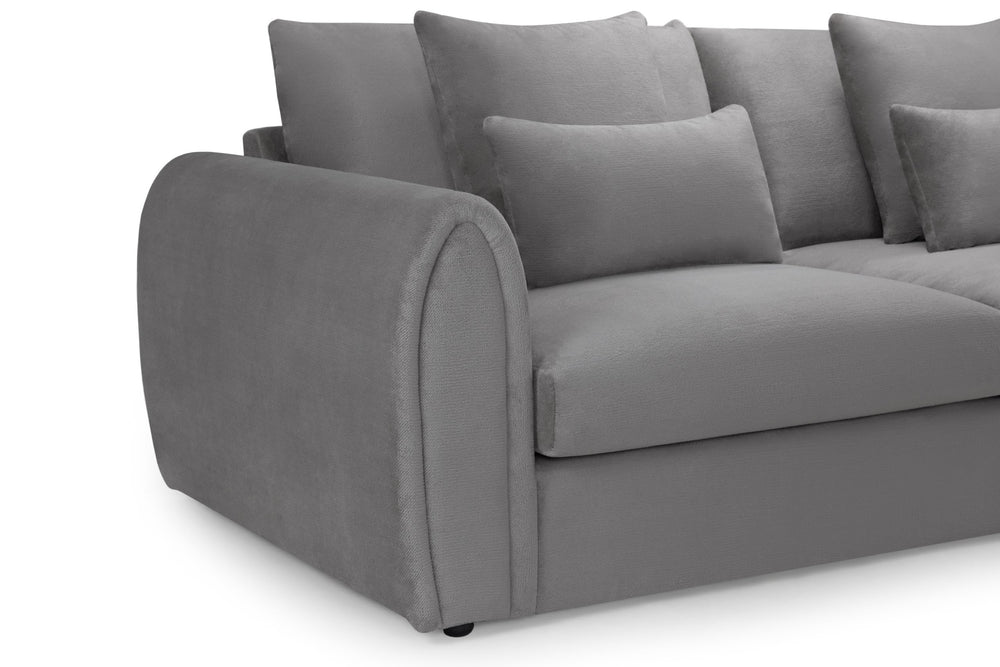 Close-up of the sofa's rounded arm, seat cushion and scatter cushions