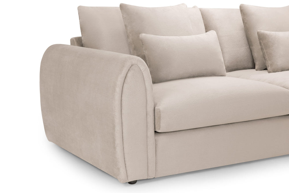 Close-up of the sofa's rounded upholstered arm, seat cushion and scatter cushions