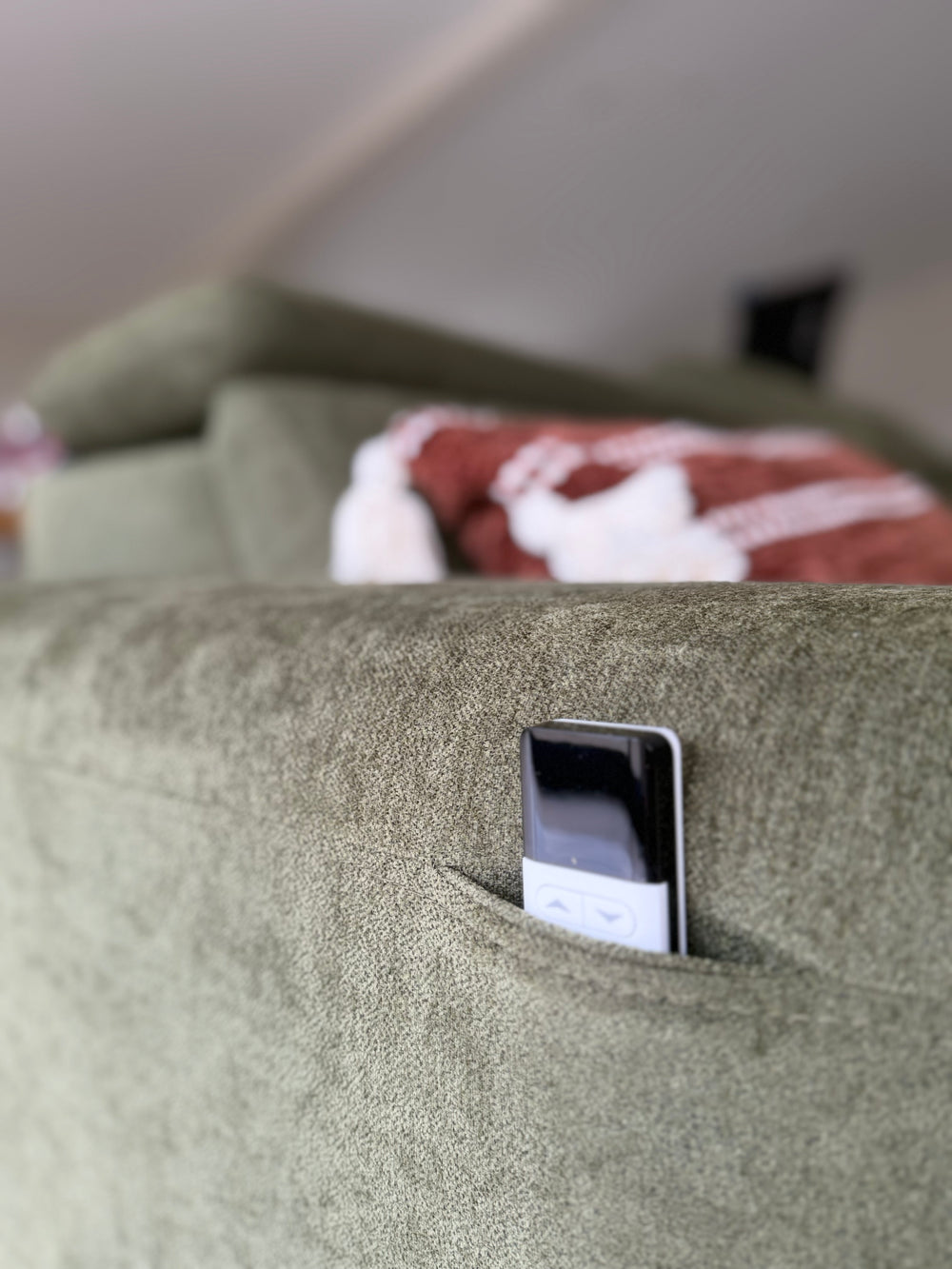 Molly three-seat electric sofa bed with a built-in control pocket on the olive upholstery