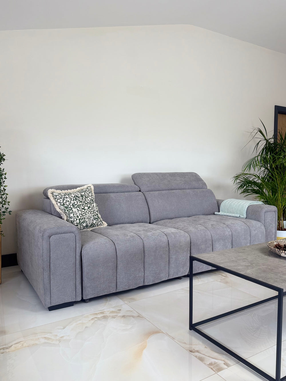 Gray three-seat sofa bed with adjustable headrests and segmented upholstery
