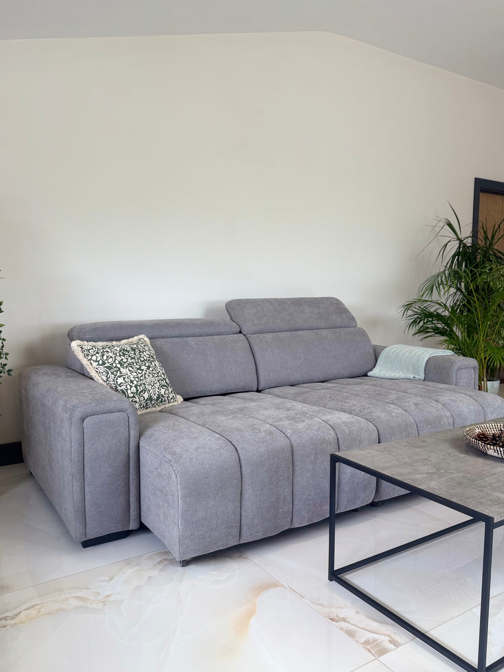 Gray sofa bed with extended seat sections, adjustable headrests, and broad armrests