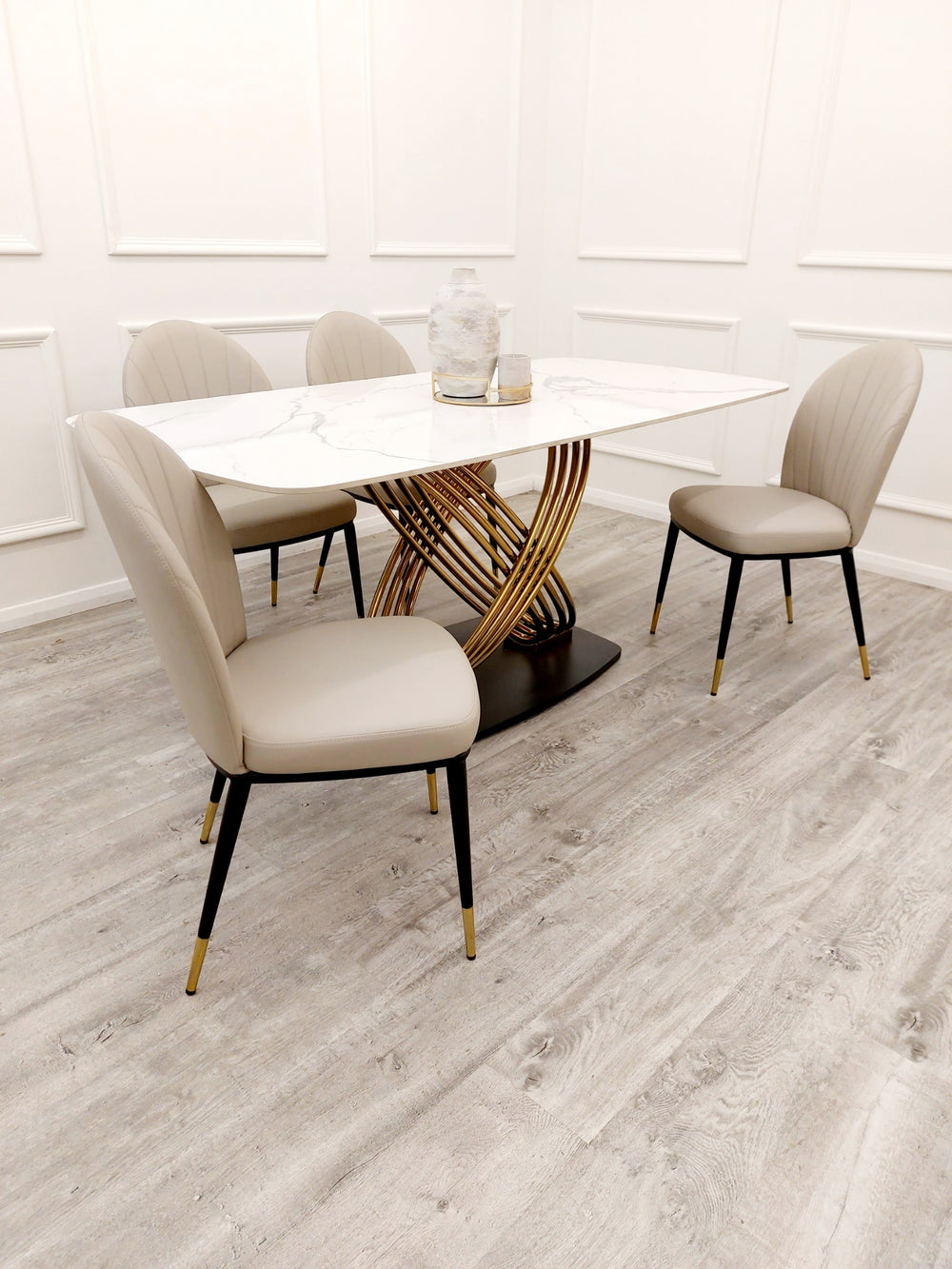 White veined stone dining table with gold pedestal base set with beige chairs